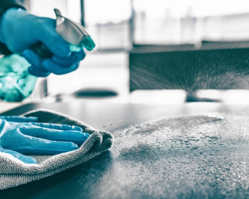 Worker sanitizing a workspace to deliver a quality cleaning experience