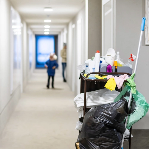 Cleaner mopping a corridor in a busy Exton office building