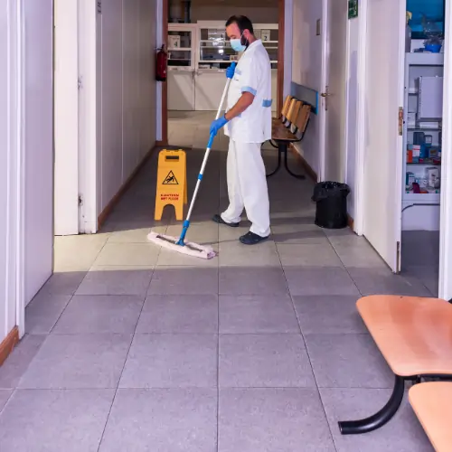Technician performing hospital-grade disinfection of medical surfaces