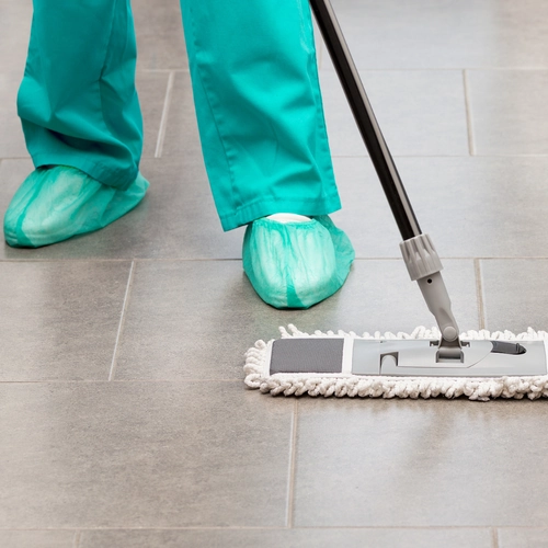 Professional cleaner disinfecting surfaces in a medical office facility