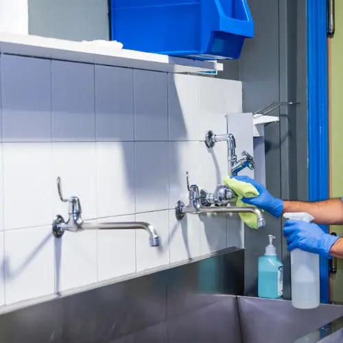 Technician disinfecting clinic surfaces to reduce infection risk