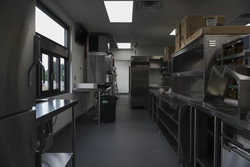 Spotless commercial kitchen with clean surfaces and overhead hood system
