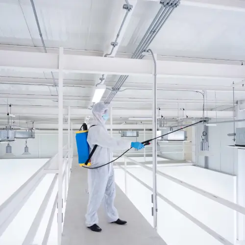 Professional cleaners scrubbing warehouse surfaces to keep operations safe and compliant